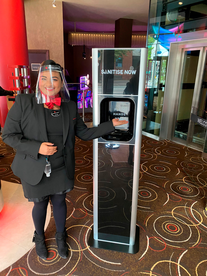 A member of the Genting team with a Sanitise Now dispenser